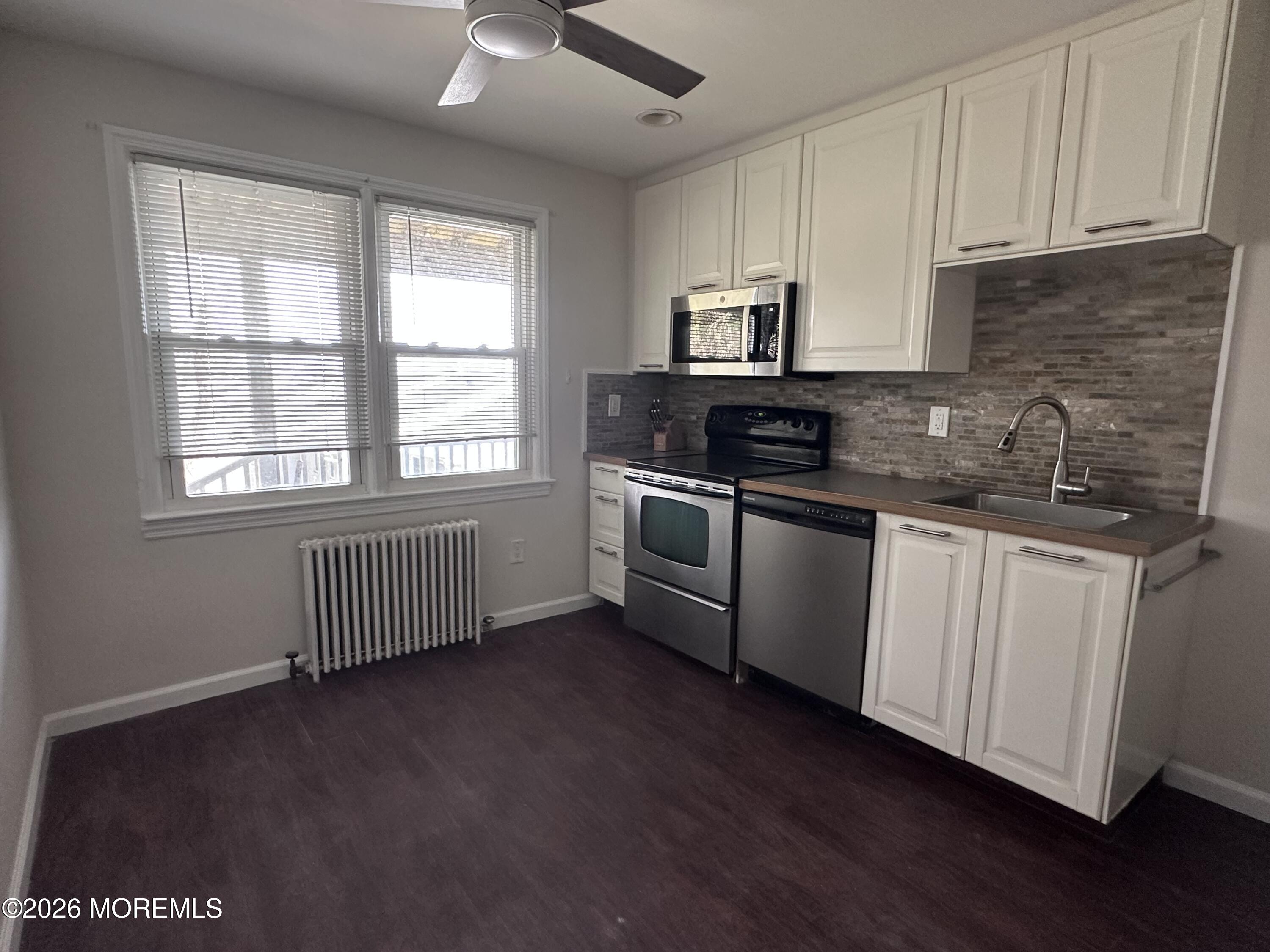 10 Ocean Street Highlands, NJ 07732 - Photo 6 of 15 a kitchen with stainless steel appliances granite countertop a sink a stove a refrigerator a sink a window and cabinets