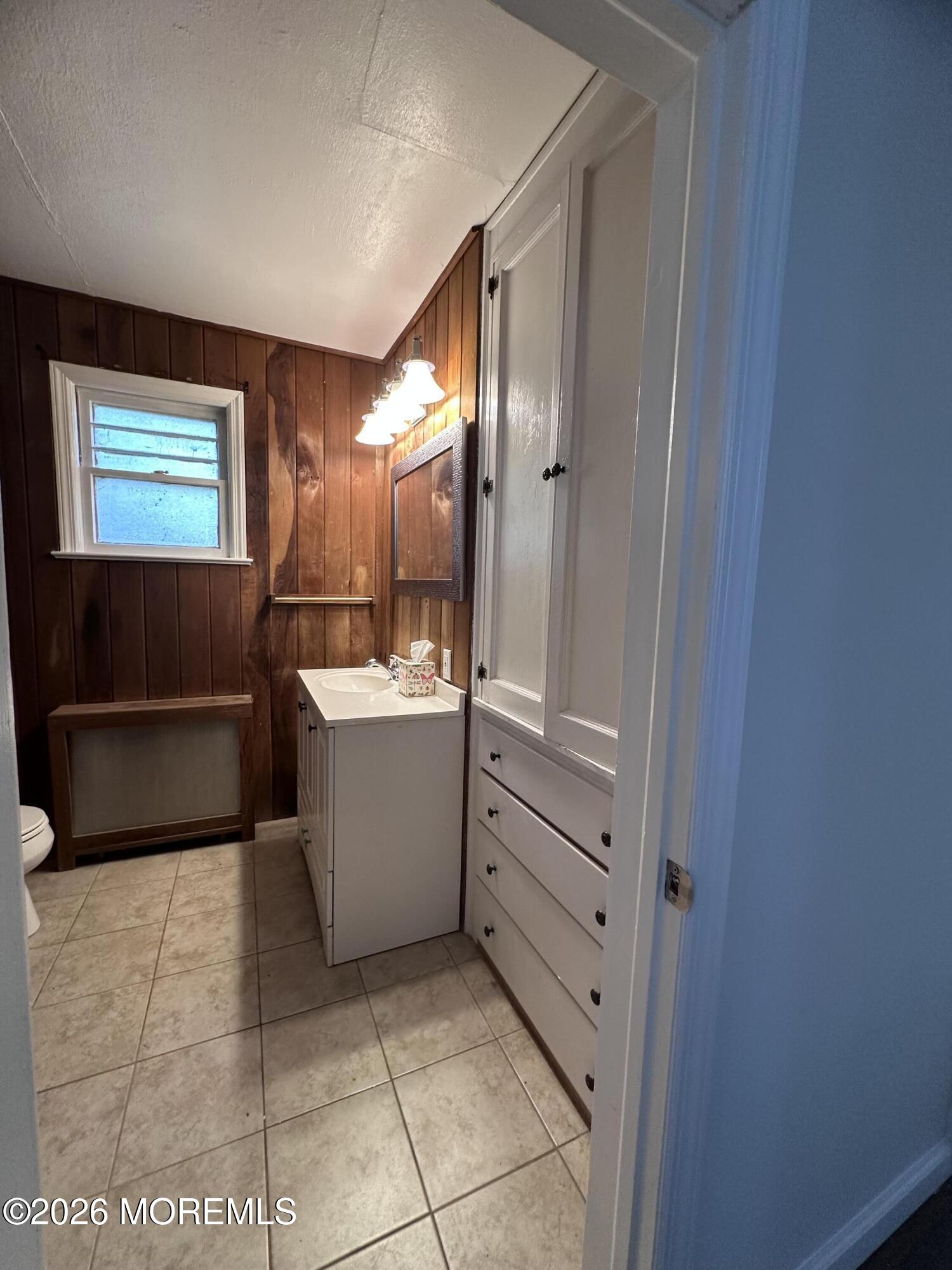 10 Ocean Street Highlands, NJ 07732 - Photo 10 of 15 a bathroom with a sink a mirror and a bathtub
