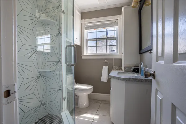 a bathroom with a granite countertop sink toilet and shower