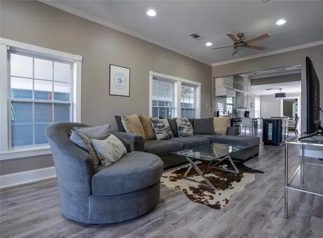 a living room with furniture and a wooden floor