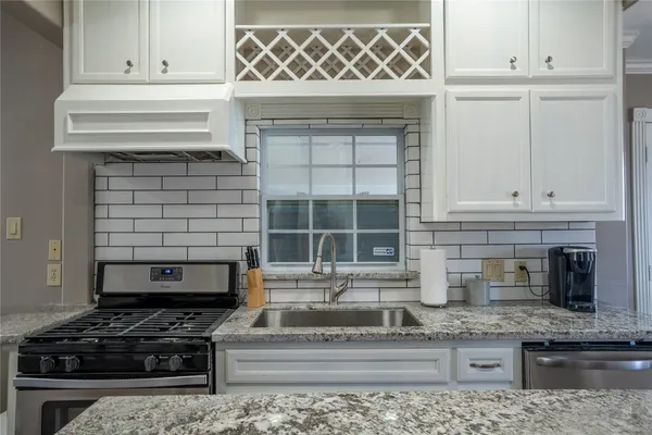 a kitchen with granite countertop a stove and a sink