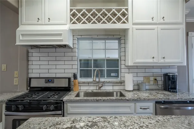 a kitchen with granite countertop a stove and a sink