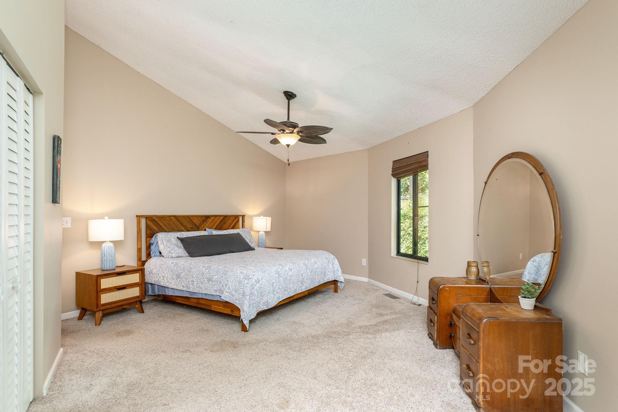78 Bryant Road Swannanoa, NC 28778 - Photo 12 of 29 a spacious bedroom with a bed and a chandelier