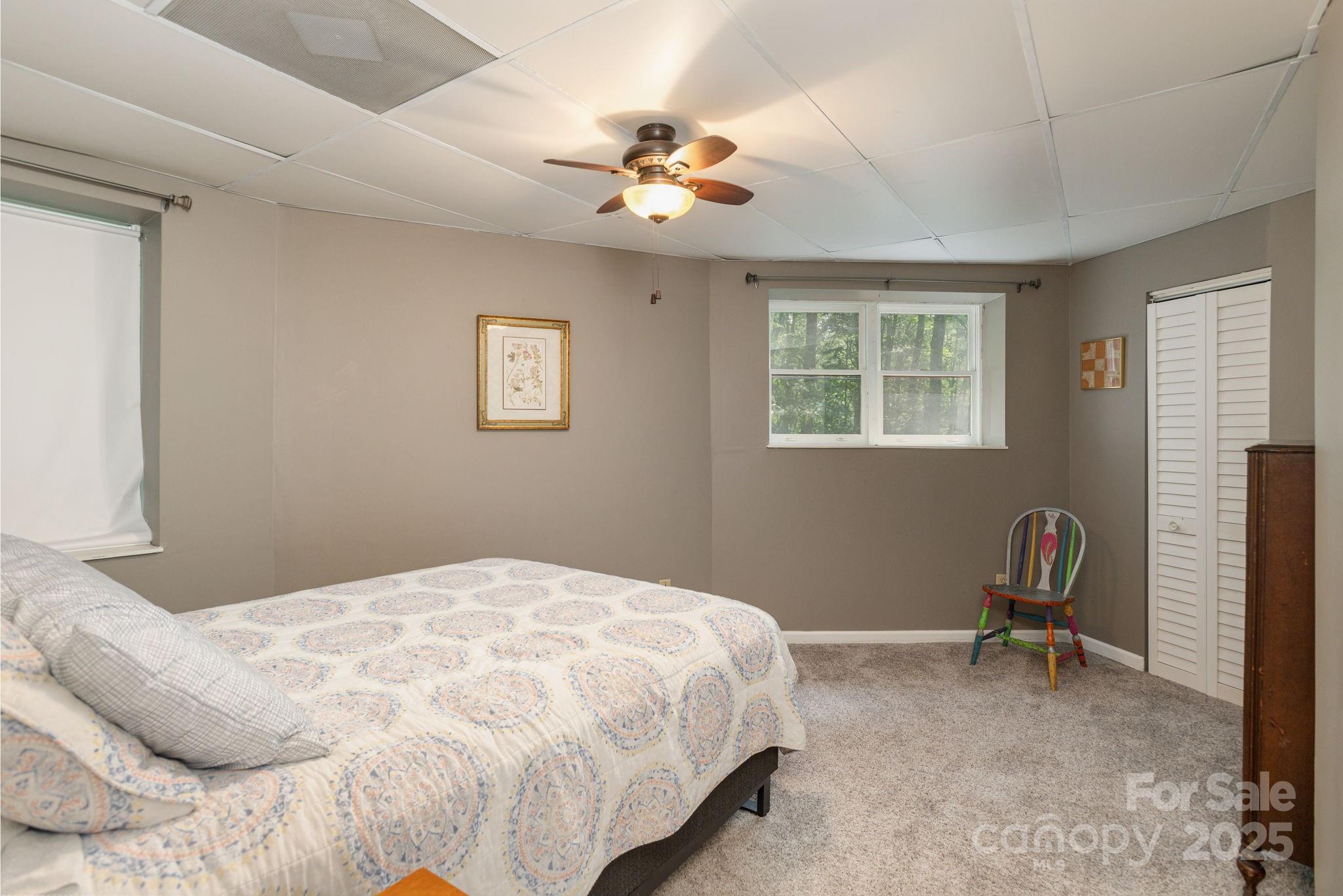 78 Bryant Road Swannanoa, NC 28778 - Photo 14 of 29 a bedroom with a bed and a chandelier