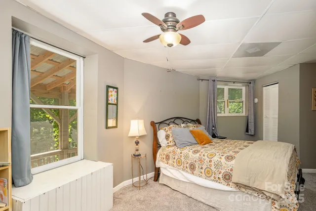 a bedroom with a large bed and two windows