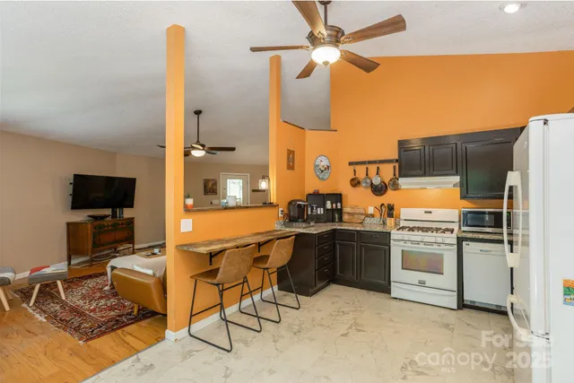 a kitchen with stainless steel appliances kitchen island granite countertop a stove and a refrigerator