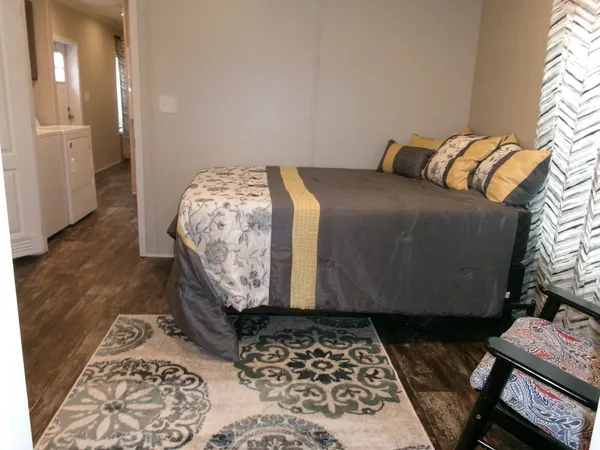 a bedroom with a bed and wooden floor