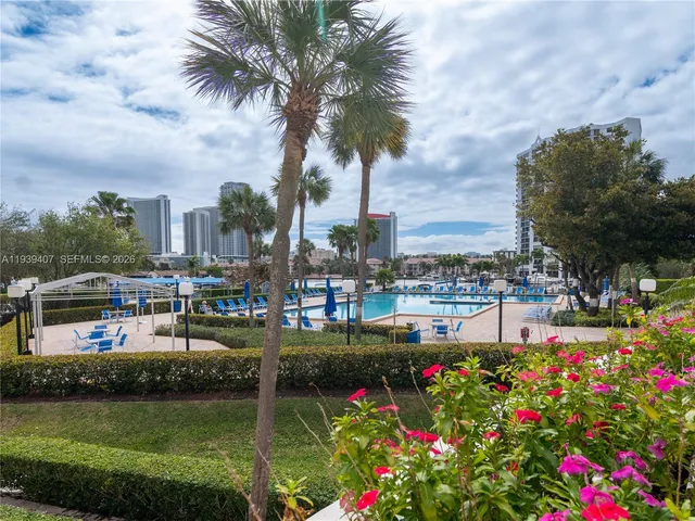 a view of a tennis ground with large trees