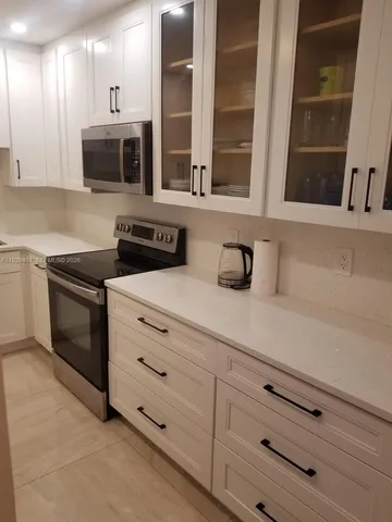 a kitchen with stainless steel appliances granite countertop a refrigerator and a stove