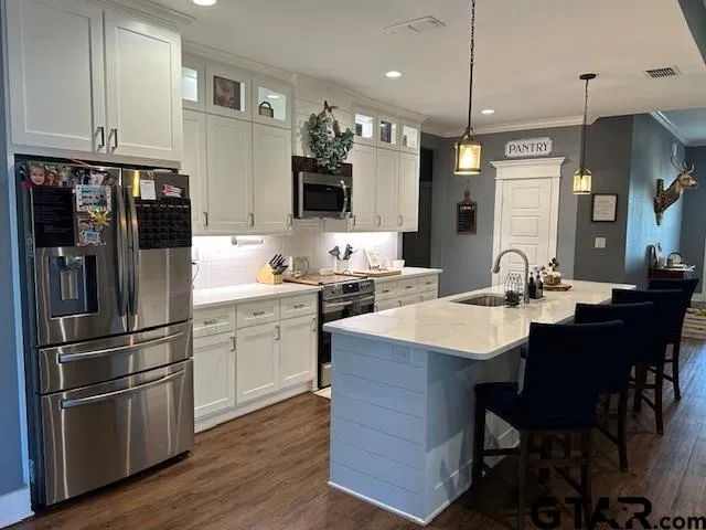 a kitchen with a sink stainless steel appliances and white cabinets