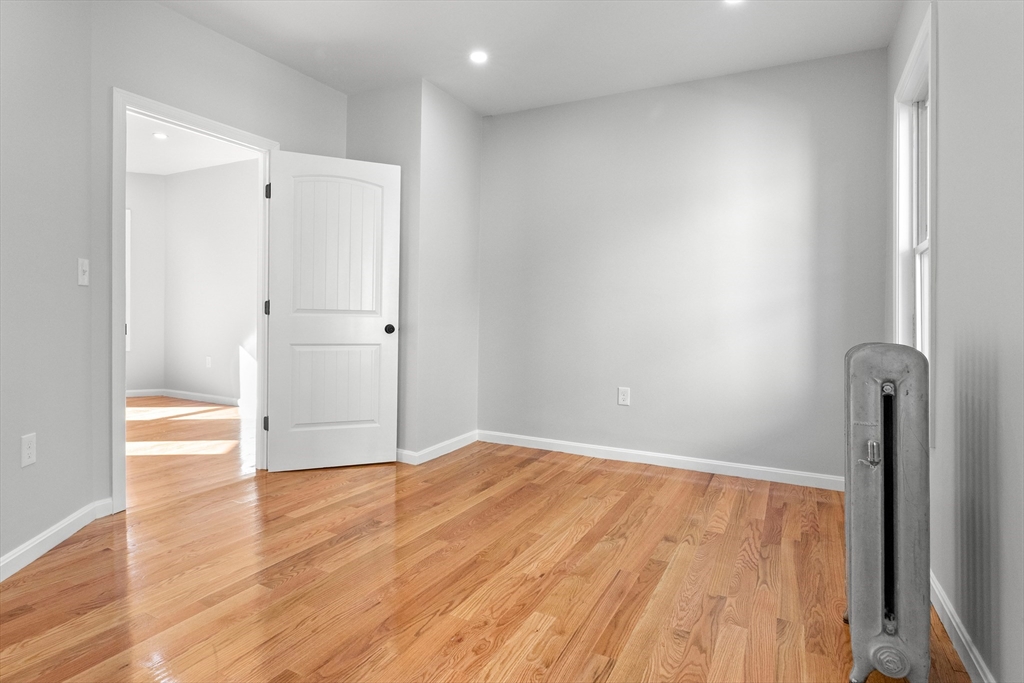 68 Middlebury Street Lawrence, MA 01841 - Photo 14 of 41 a view of an empty room with wooden floor and a bathroom