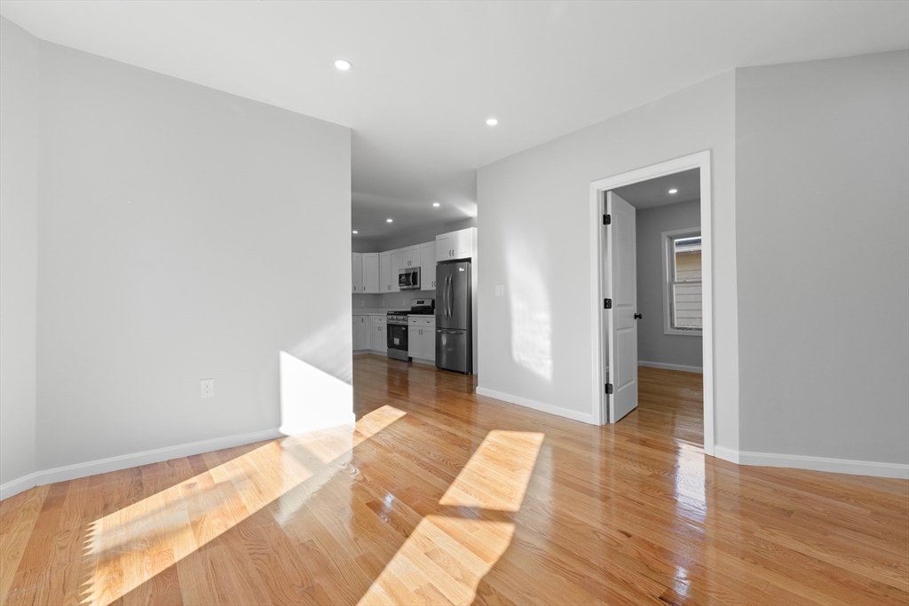 68 Middlebury Street Lawrence, MA 01841 - Photo 4 of 41 a view of a hallway with wooden floor and a bathroom