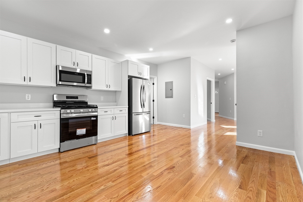 68 Middlebury Street Lawrence, MA 01841 - Photo 5 of 41 a kitchen with granite countertop a refrigerator and a stove top oven