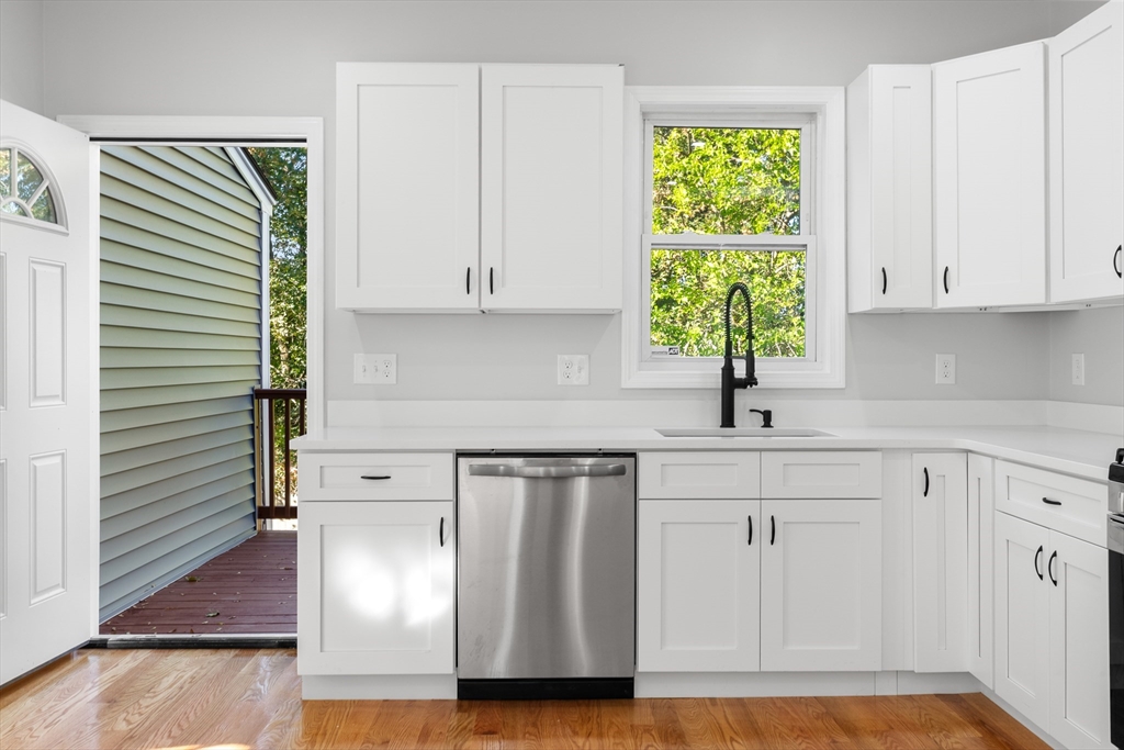 68 Middlebury Street Lawrence, MA 01841 - Photo 7 of 41 a kitchen with stainless steel appliances a white cabinets and a window
