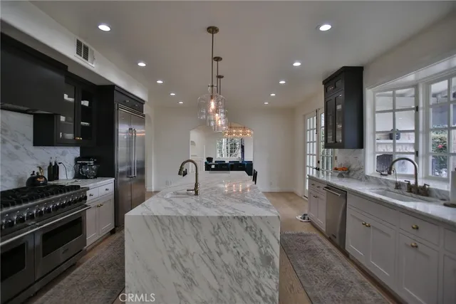 a kitchen with stainless steel appliances granite countertop a stove a sink and a refrigerator