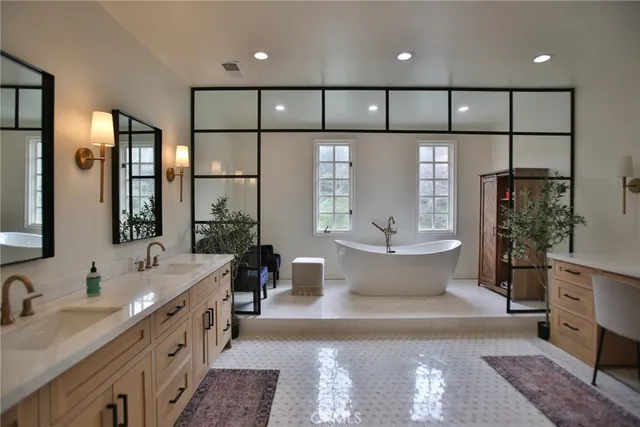 a large spacious bathroom with a double vanity sink a large mirror and a bathtub