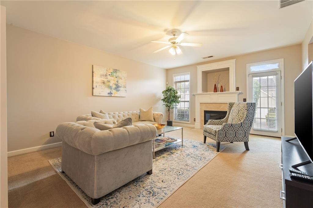 878 Scales Road Suwanee, GA 30024 - Photo 6 of 17 a living room with furniture a fireplace and a flat screen tv