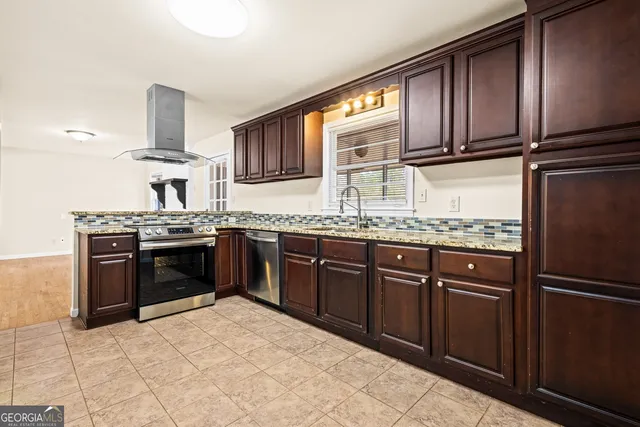 a kitchen with stainless steel appliances granite countertop a stove sink and cabinets