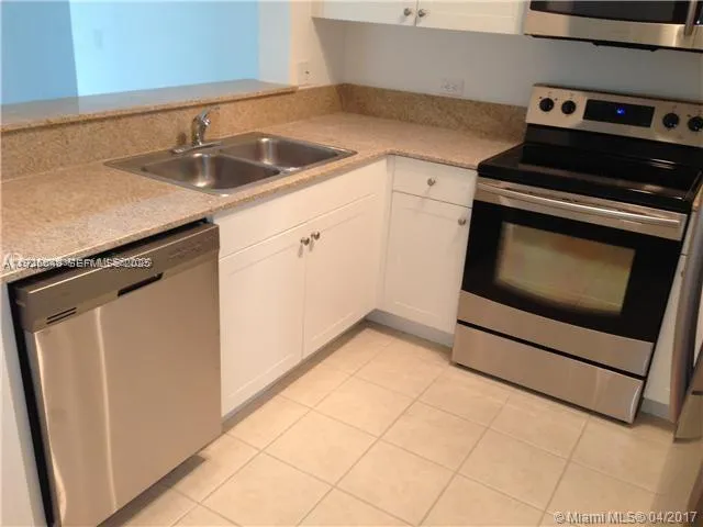 a kitchen with stainless steel appliances granite countertop a refrigerator and a microwave
