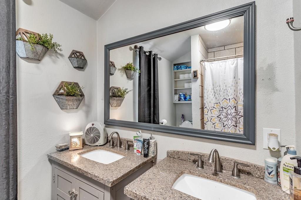 6597 County Lane 14 Ordway, CO 81063 - Photo 17 of 66 a bathroom with a granite countertop sink mirror and vanity