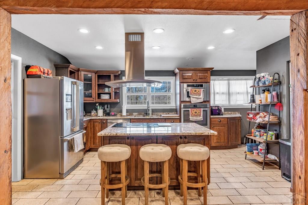 6597 County Lane 14 Ordway, CO 81063 - Photo 9 of 66 a kitchen with stainless steel appliances granite countertop a table chairs and a refrigerator