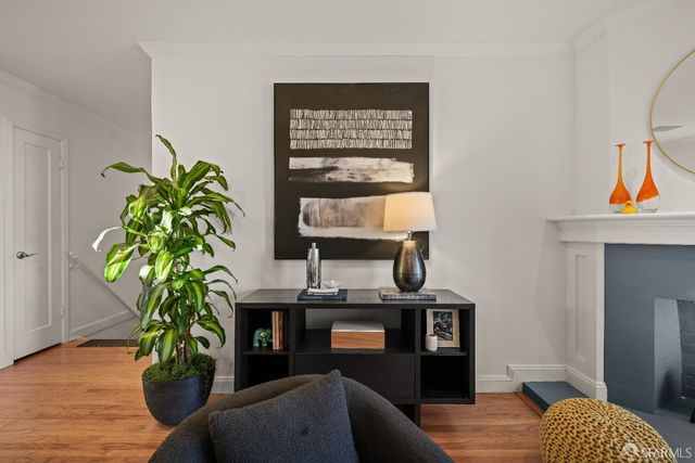 a living room with furniture a fireplace and a potted plant