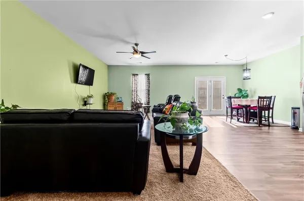 a living room with furniture a dining table and a potted plant