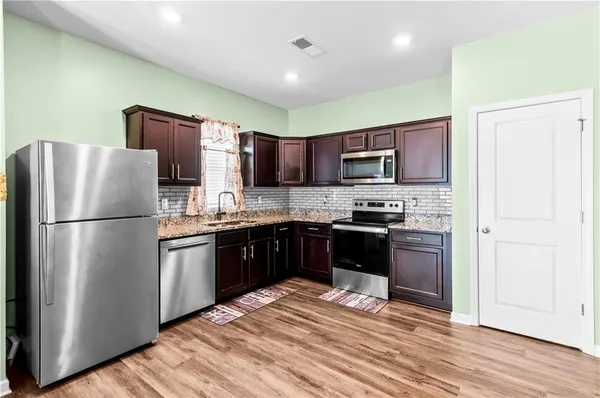 a kitchen with a refrigerator stove top oven and sink