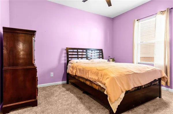 a bed room with a bed and a refrigerator