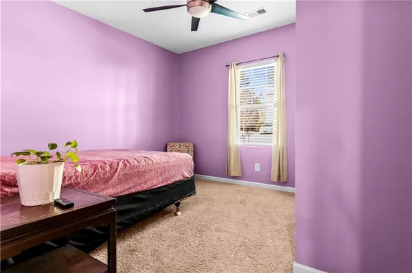 a bedroom with pink walls and chandelier