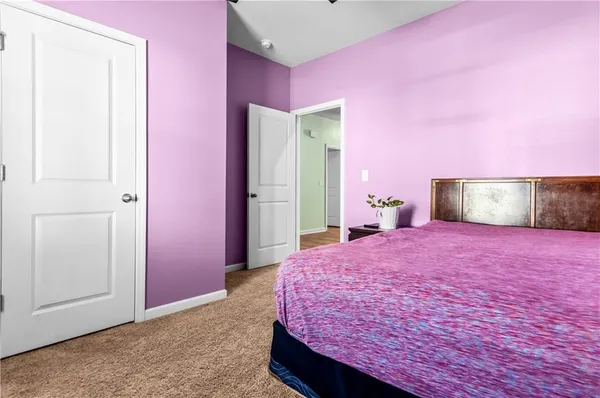 a bedroom with pink walls and pink rug