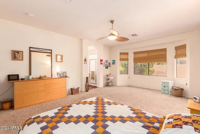 a bedroom with a bed and dresser with mirror