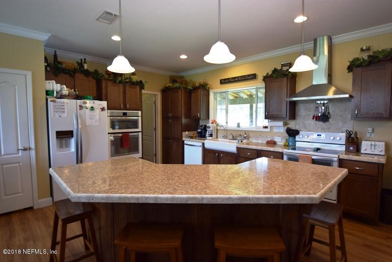 110 Jones Road Crescent City, FL 32112 - Photo 18 of 55 a large kitchen with a table chairs refrigerator and wooden floor