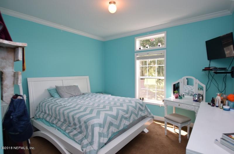 110 Jones Road Crescent City, FL 32112 - Photo 25 of 55 a bedroom with a bed and a flat tv screen on dresser