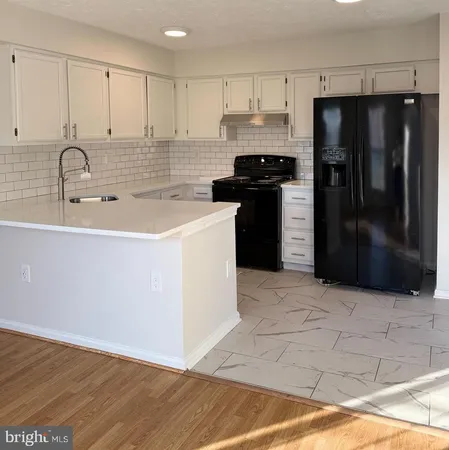a kitchen with stainless steel appliances a refrigerator sink and cabinets