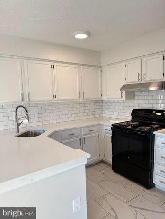 a kitchen with a sink and a stove top oven