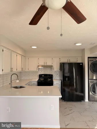 a kitchen with stainless steel appliances a refrigerator a sink a stove and cabinets