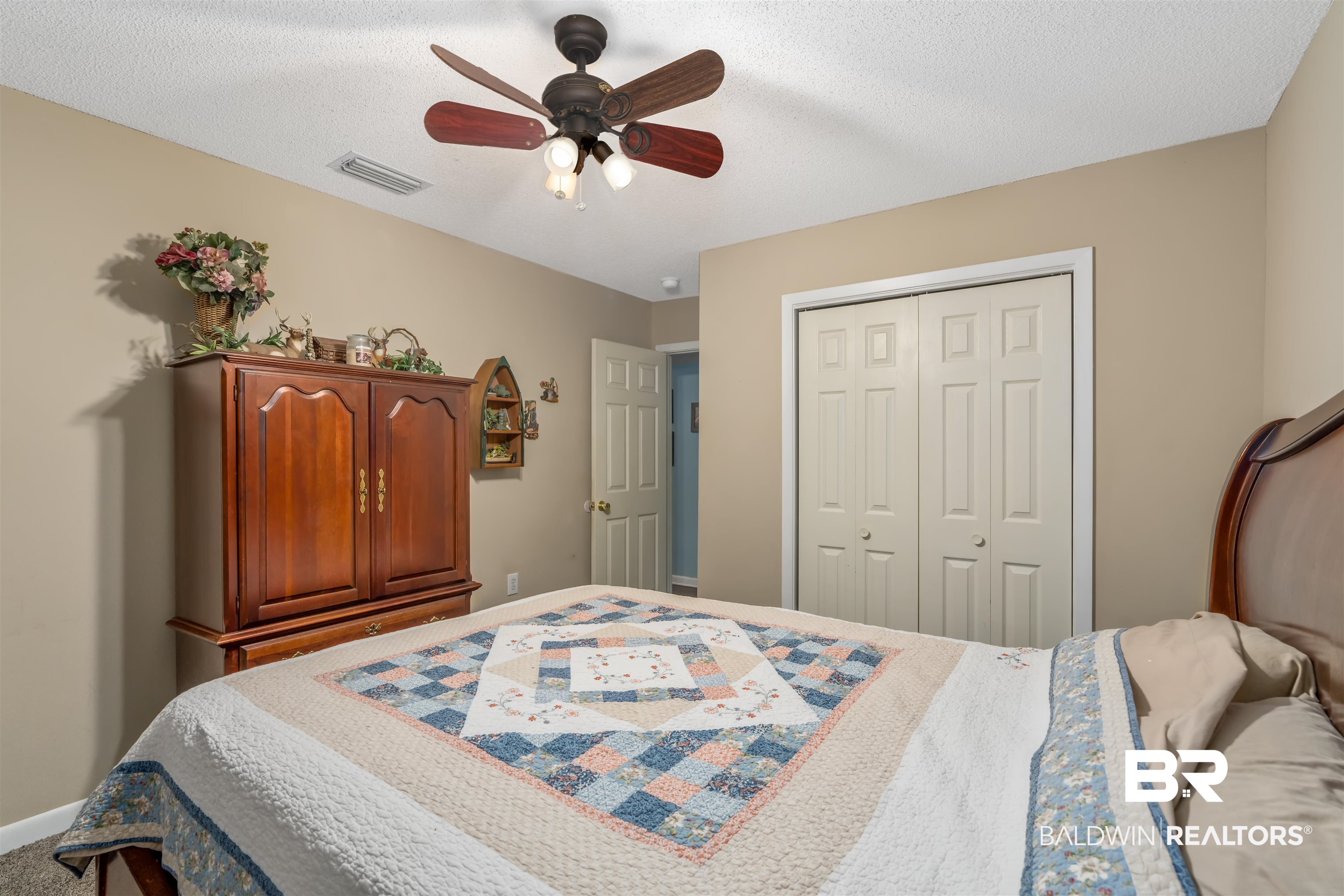 23186 Pecan Street Robertsdale, AL 36567 - Photo 14 of 36 Bedroom with ceiling fan, a textured ceiling, and a closet