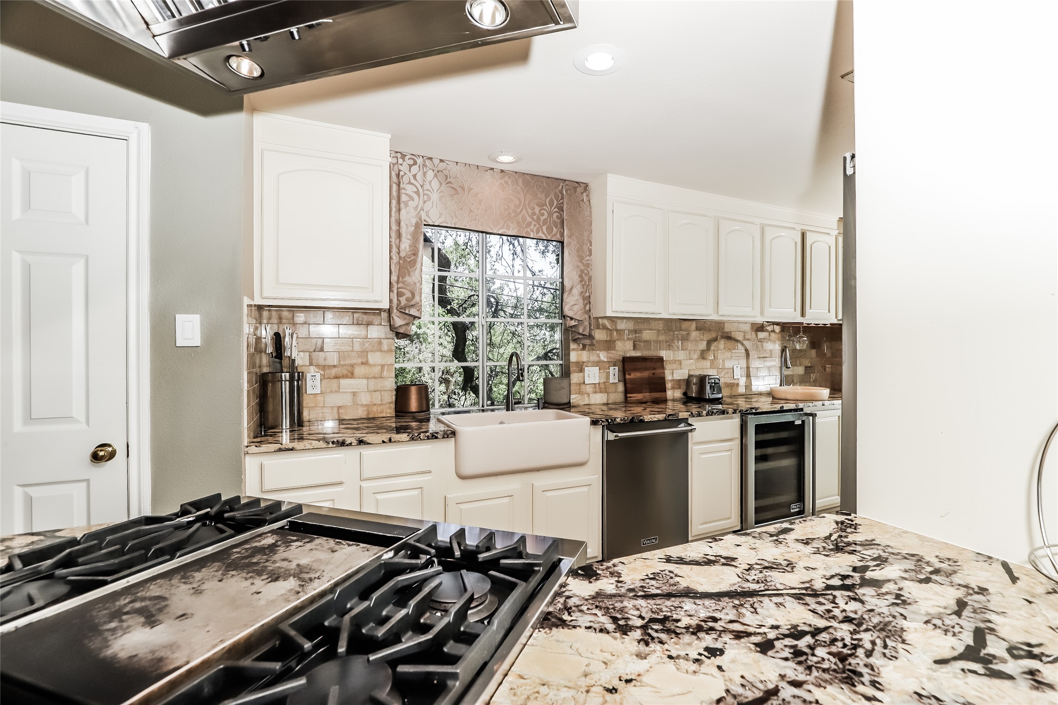 1702 Newning Avenue, Unit A Austin, TX 78704 - Photo 7 of 20 Gourmet kitchen featuring a built-in gas range, stainless steel vent hood, expansive stone countertops, white cabinetry, and a farmhouse sink