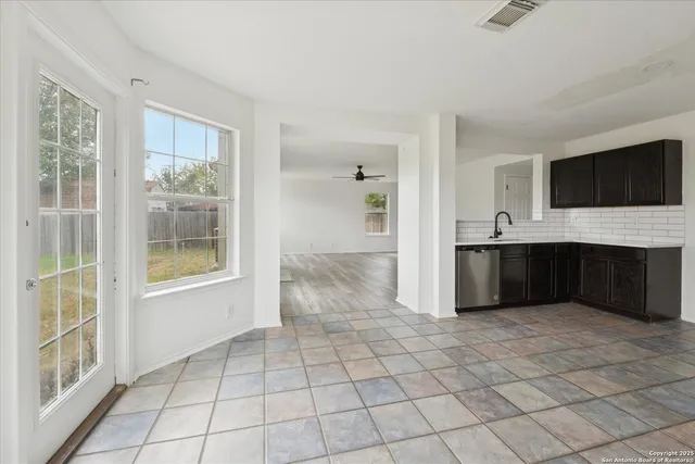a view of an empty room with a fireplace and a window