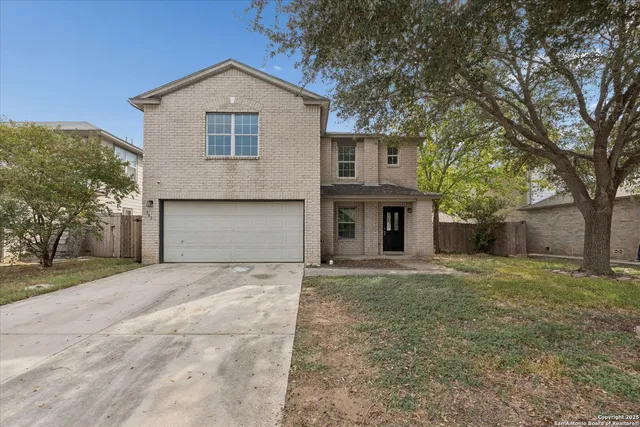 a front view of a house with yard and trees