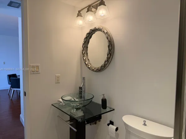 a bathroom with a toilet a sink and mirror