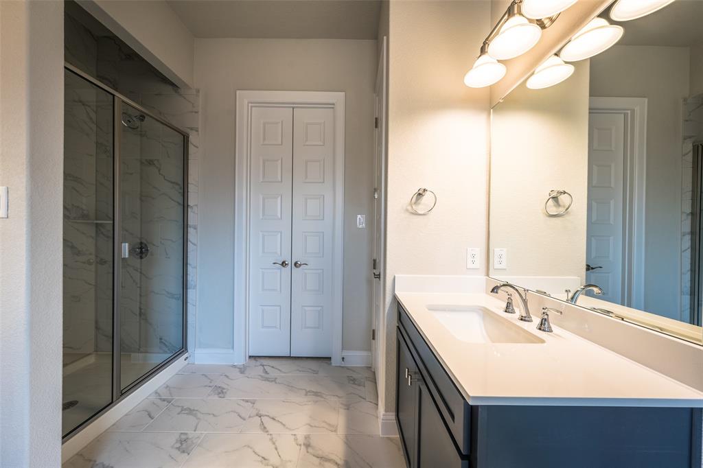113 Old Trinity Way Georgetown, TX 78628 - Photo 17 of 27 Bathroom with a closet, vanity, light marble finish flooring, and a marble finish shower
