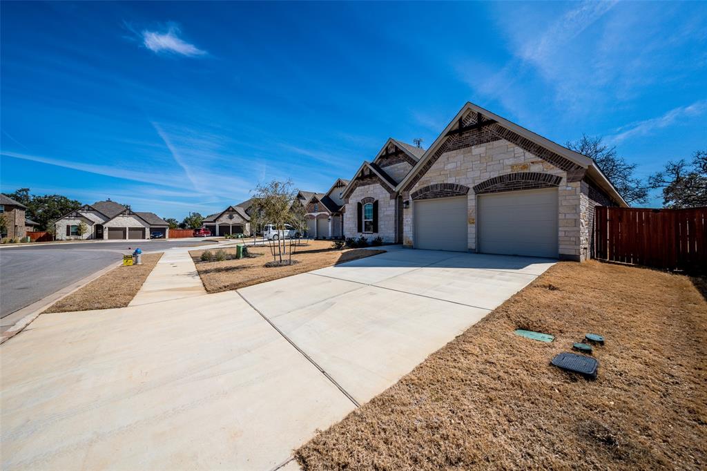 113 Old Trinity Way Georgetown, TX 78628 - Photo 2 of 27 French country inspired facade featuring stone siding, driveway, a residential view, and a garage