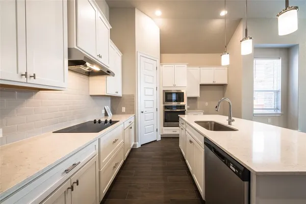 a kitchen with a sink stove and cabinets