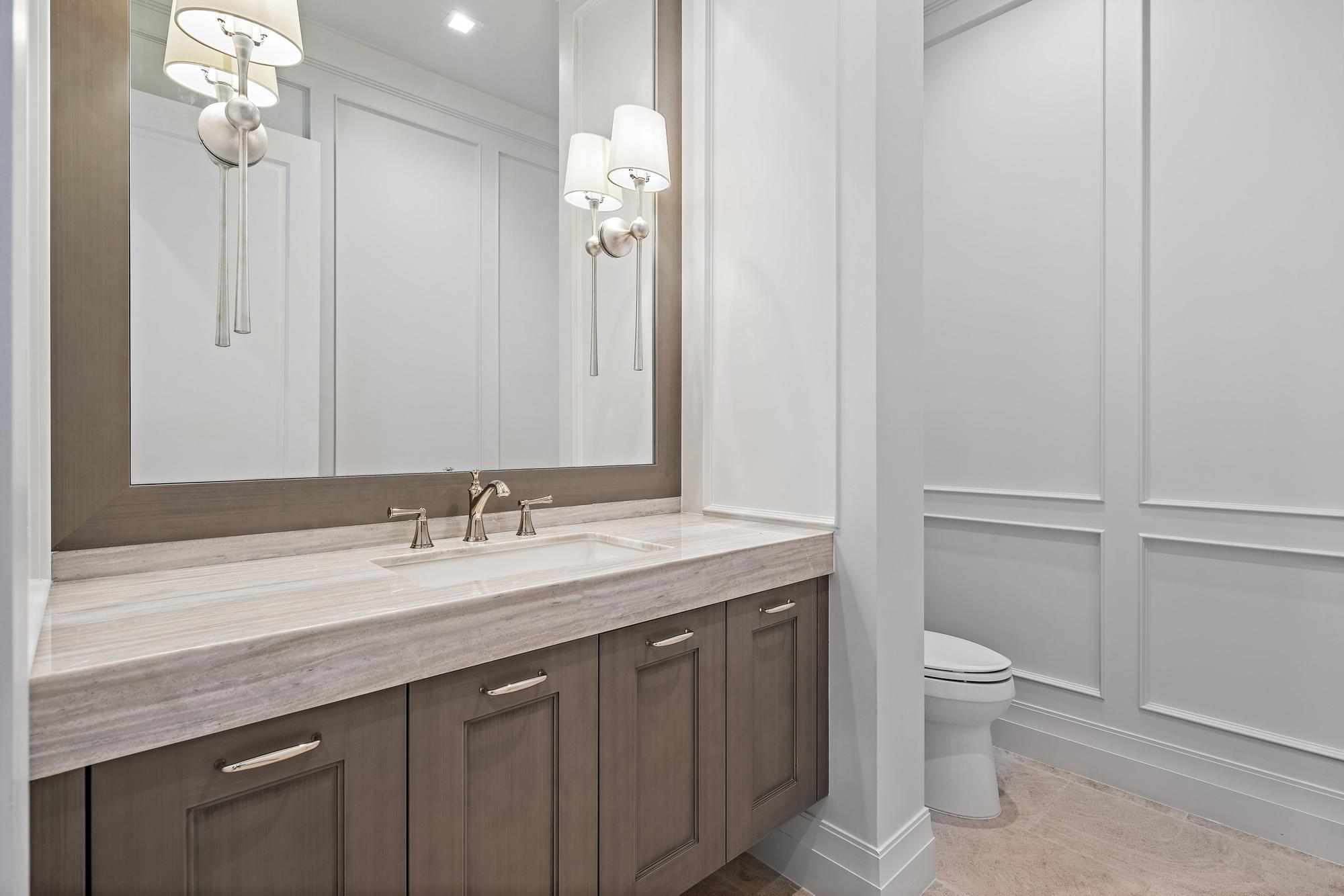 2917 Bluewater Cove Gulf Stream, FL 33483 - Photo 16 of 37 a bathroom with a granite countertop sink a toilet and a mirror