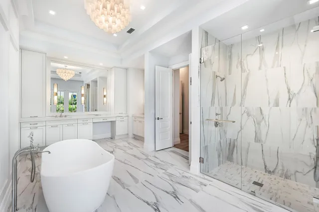 a spacious bathroom with a shower a sink and a mirror