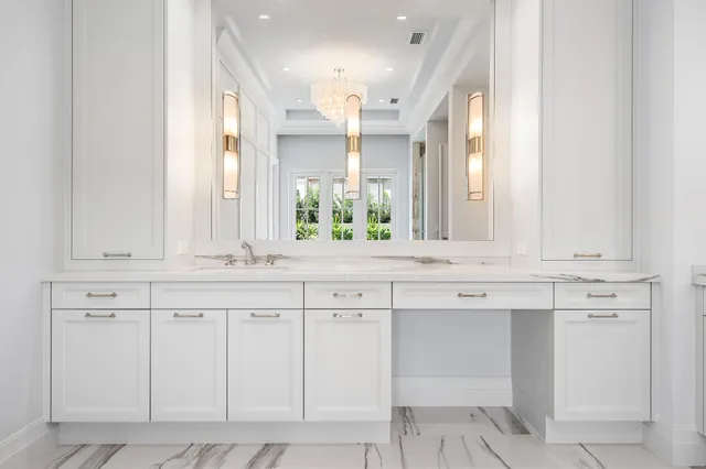 a bathroom with white cabinets and a sink