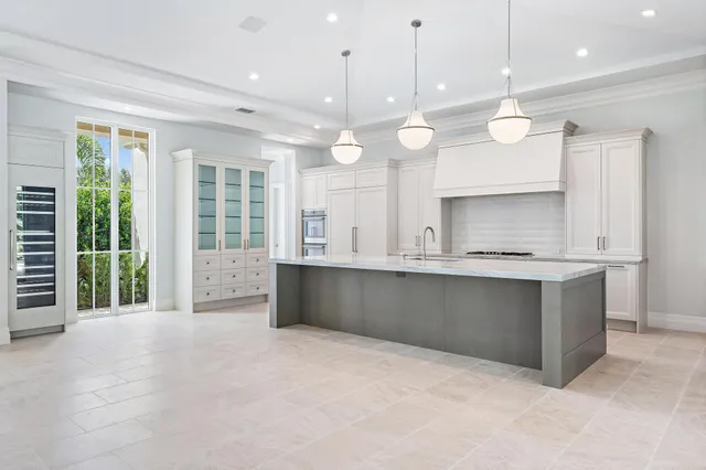 a large kitchen with kitchen island granite countertop a sink a counter space and stainless steel appliances