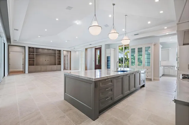 a large white kitchen with a large island in the center